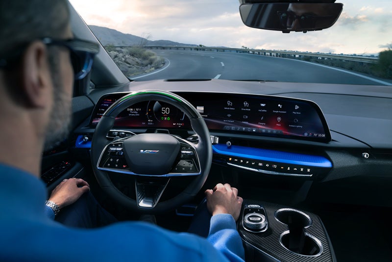 Front View of the 2026 OPTIQ-V Driving Through the Dusk Utilizing its Headlights | Huston Cadillac in LAKE WALES FL